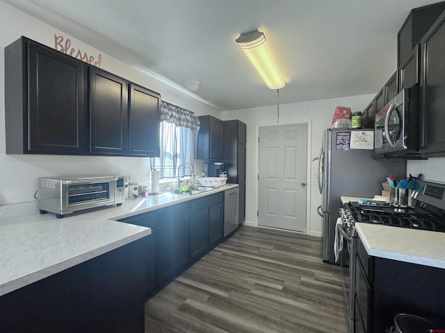 kitchen featuring stainless steel appliances, sink, and dark hardwood / wood-style floors