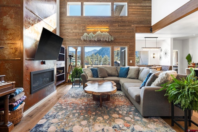 living room with a towering ceiling, wood walls, and a wealth of natural light