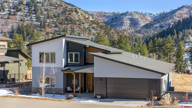 modern home featuring a garage and a mountain view