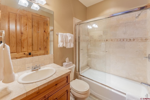 full bathroom featuring toilet, bath / shower combo with glass door, backsplash, and vanity