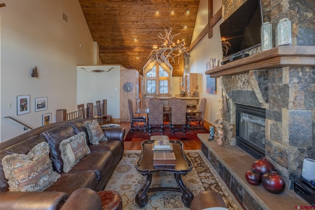 living room with a stone fireplace, an inviting chandelier, high vaulted ceiling, and wood-type flooring