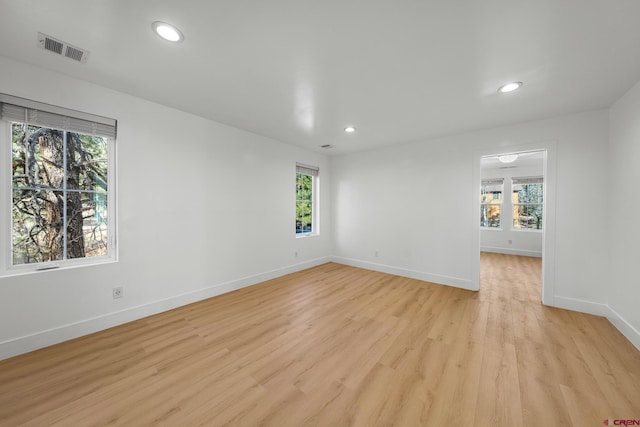 spare room with a healthy amount of sunlight and light hardwood / wood-style flooring