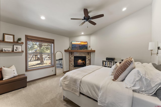 bedroom with ceiling fan, light carpet, and a fireplace