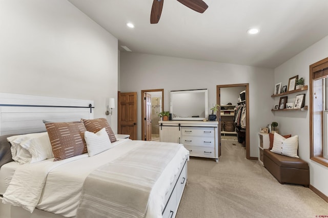 carpeted bedroom with a spacious closet, ceiling fan, a closet, and vaulted ceiling