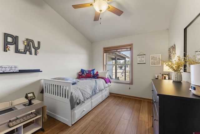 bedroom featuring ceiling fan, hardwood / wood-style flooring, and vaulted ceiling