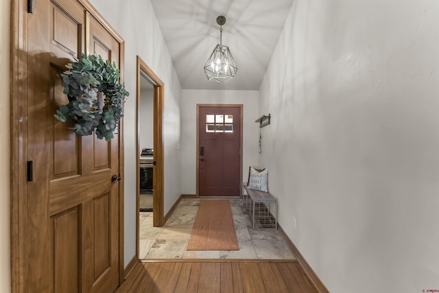 doorway with light wood-type flooring and a chandelier