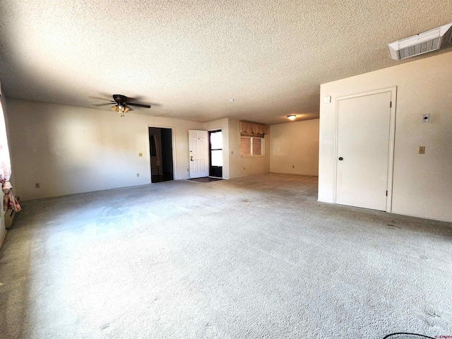 unfurnished living room with ceiling fan and a textured ceiling