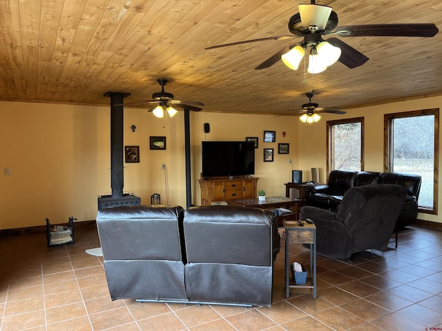 living room with wooden ceiling, a wood stove, light tile patterned floors, and ceiling fan