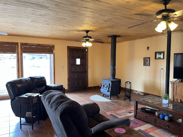 tiled living room featuring ceiling fan, wood ceiling, and a wood stove