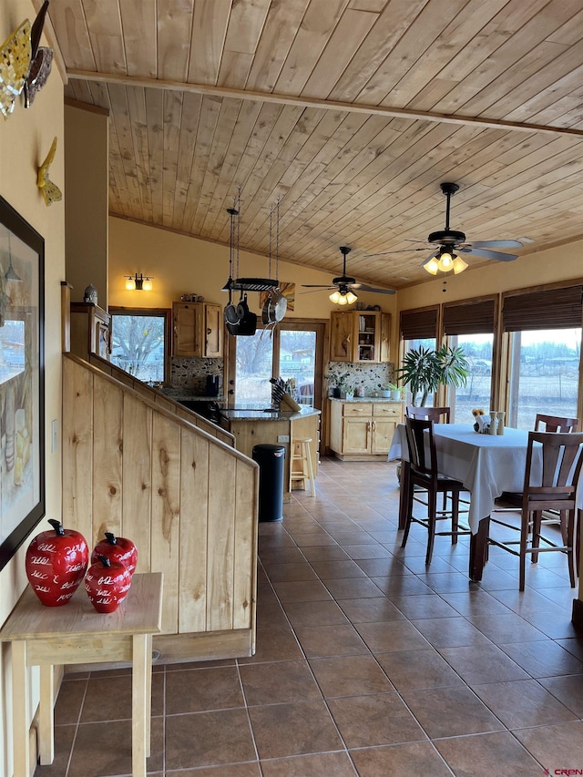 kitchen featuring kitchen peninsula, wooden ceiling, backsplash, vaulted ceiling, and dark tile patterned floors