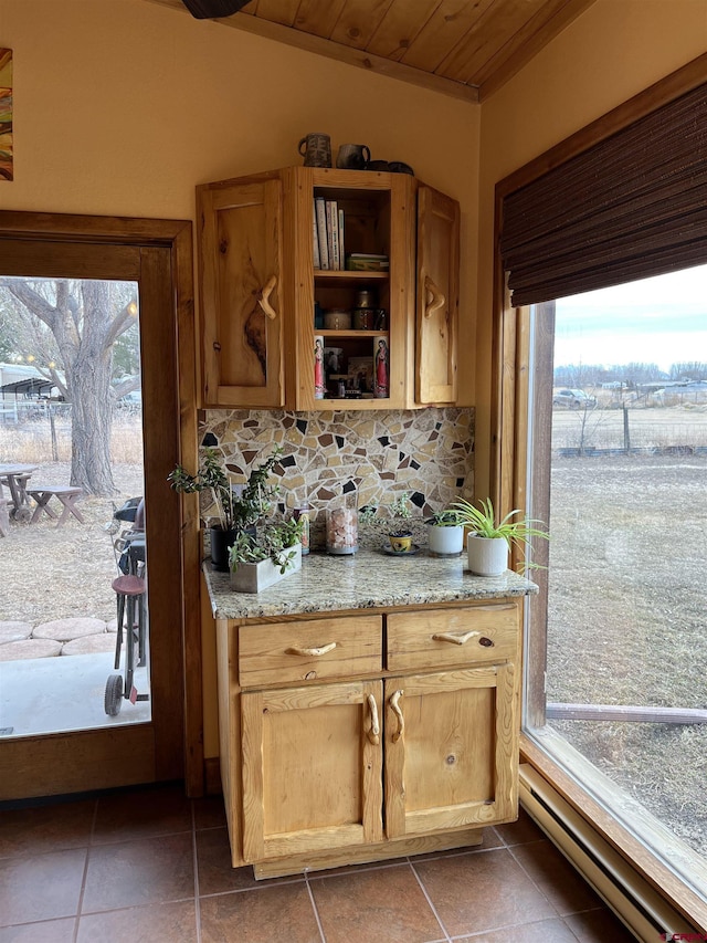 kitchen featuring light stone countertops, baseboard heating, plenty of natural light, and wooden ceiling