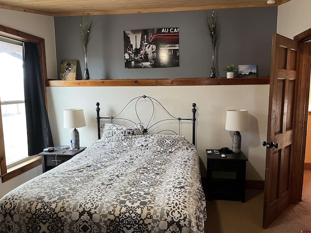 bedroom featuring wooden ceiling and multiple windows