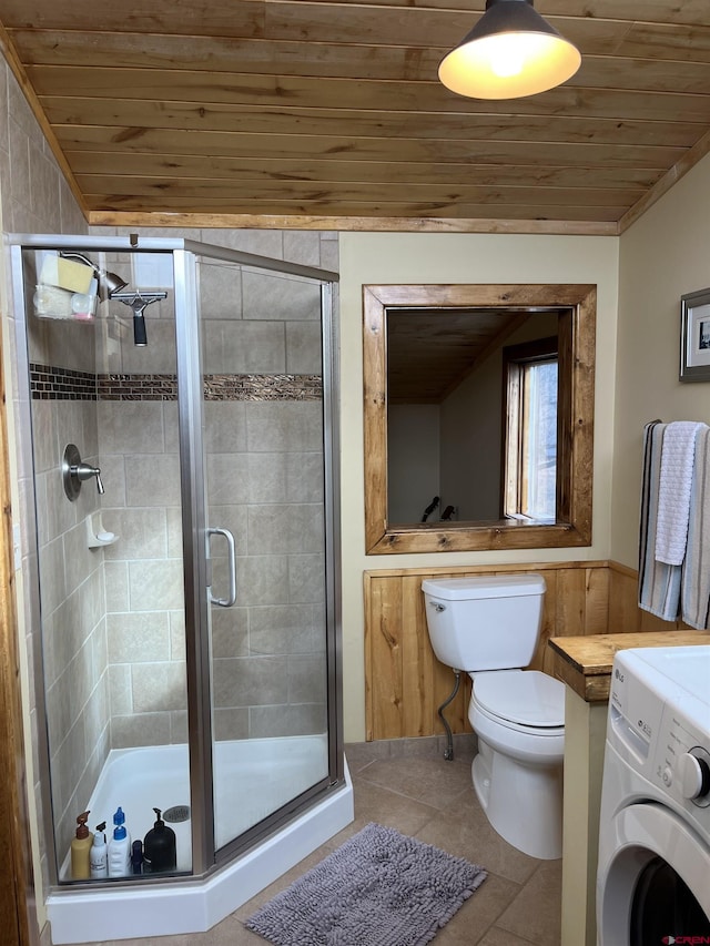 bathroom featuring toilet, tile patterned flooring, washer / dryer, wood ceiling, and a shower with door