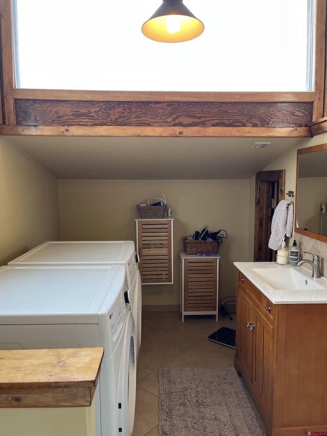 laundry area featuring cabinets, sink, washer and clothes dryer, and light tile patterned flooring