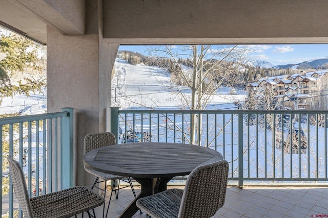 snow covered back of property with a mountain view