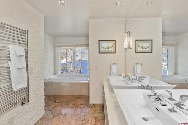 bathroom featuring radiator heating unit, a wealth of natural light, and a relaxing tiled tub