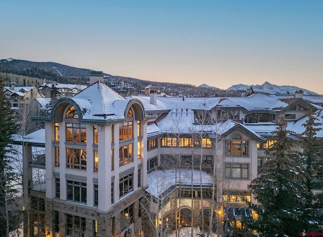 snow covered house featuring a mountain view