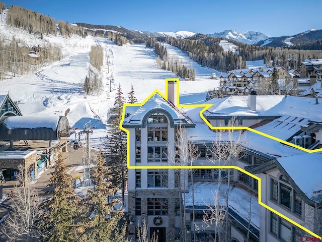 snowy aerial view featuring a mountain view