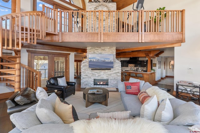 living room featuring french doors, a fireplace, and a high ceiling