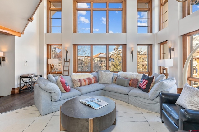 living room featuring light wood-type flooring and a high ceiling