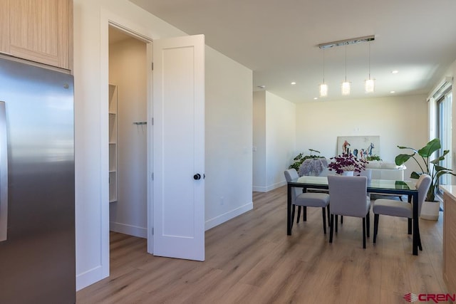 dining room with rail lighting and light hardwood / wood-style floors