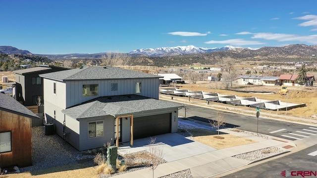 view of front facade with central AC unit, a garage, and a mountain view