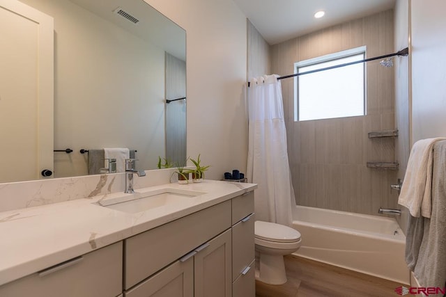 full bathroom with shower / bathtub combination with curtain, vanity, toilet, and hardwood / wood-style floors