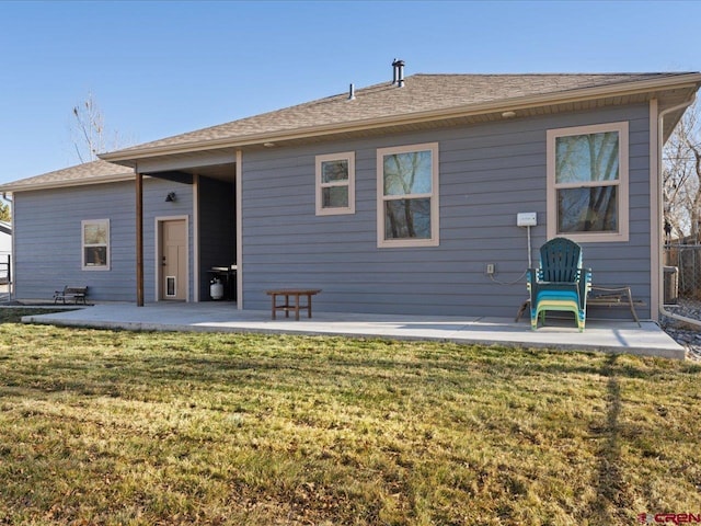 rear view of property featuring a yard and a patio