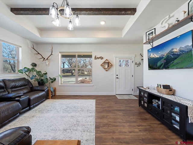 living room featuring dark hardwood / wood-style flooring, a raised ceiling, and a notable chandelier