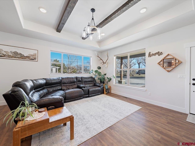 living room featuring a raised ceiling, dark hardwood / wood-style flooring, beamed ceiling, and an inviting chandelier