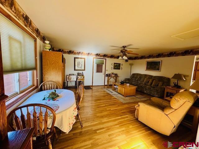 living room featuring light wood-type flooring and ceiling fan