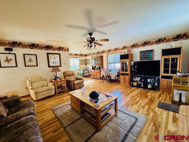 living room featuring ceiling fan and wood-type flooring