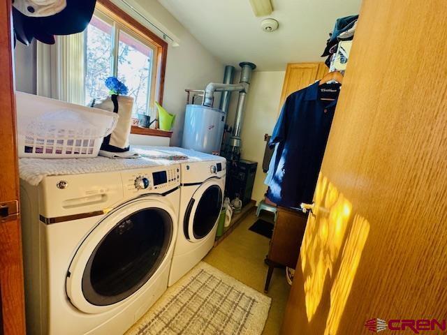 washroom with washing machine and dryer and gas water heater