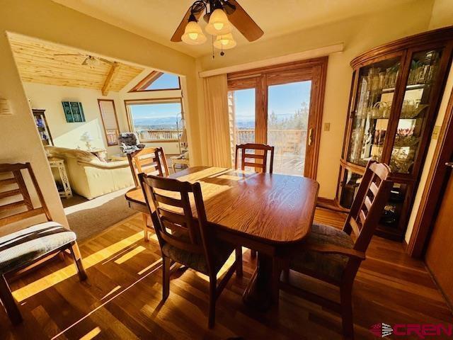 dining space with ceiling fan, dark hardwood / wood-style flooring, plenty of natural light, and wooden ceiling