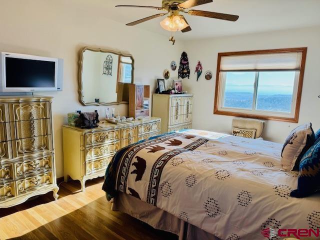 bedroom with ceiling fan and wood-type flooring