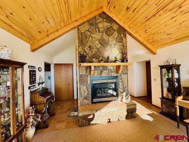 living room featuring high vaulted ceiling, tile patterned flooring, a fireplace, and wooden ceiling