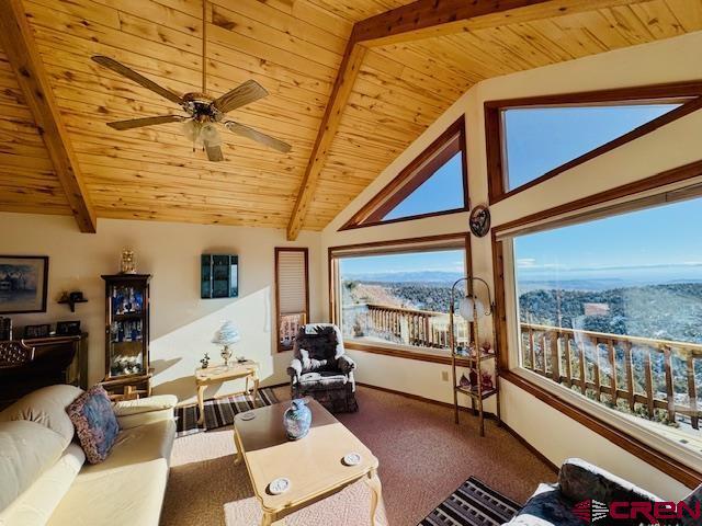 interior space with ceiling fan, carpet, lofted ceiling with beams, and wood ceiling