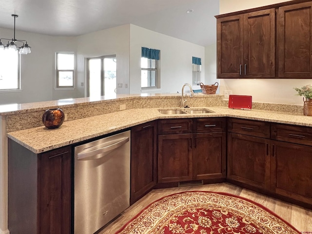 kitchen with an inviting chandelier, light wood-type flooring, stainless steel dishwasher, light stone counters, and sink