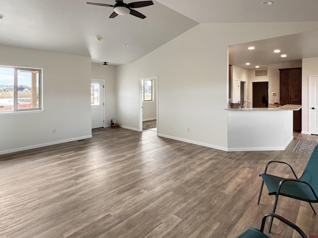 unfurnished living room featuring ceiling fan, lofted ceiling, and hardwood / wood-style floors