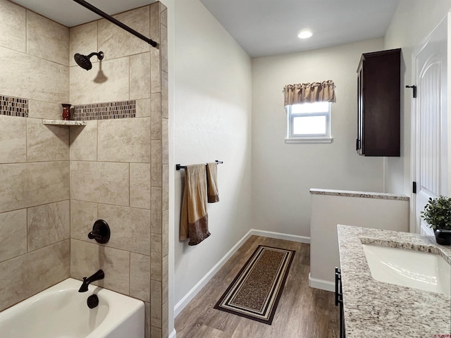 bathroom featuring tiled shower / bath combo, vanity, and hardwood / wood-style flooring