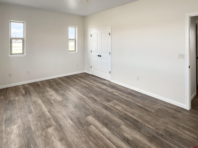 empty room with dark hardwood / wood-style flooring