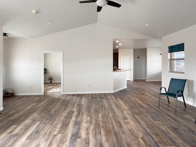 unfurnished living room featuring ceiling fan, dark hardwood / wood-style floors, and vaulted ceiling