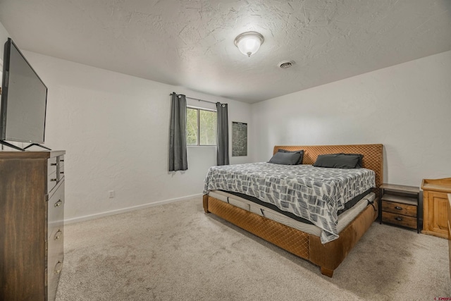 bedroom featuring light carpet and a textured ceiling