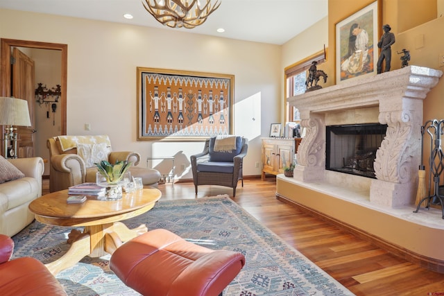 living room featuring light hardwood / wood-style floors, a notable chandelier, and a fireplace