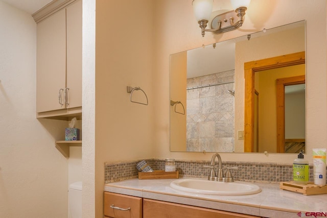 bathroom featuring toilet, vanity, backsplash, and walk in shower