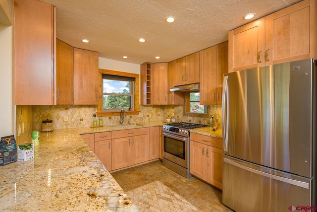 kitchen with decorative backsplash, sink, light brown cabinets, stainless steel appliances, and light stone counters