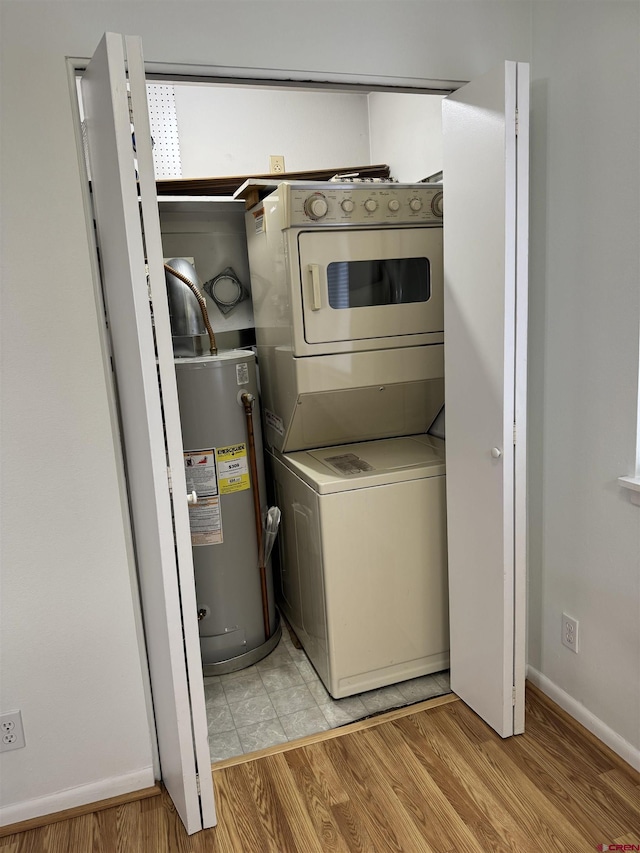 laundry area with stacked washing maching and dryer, light hardwood / wood-style flooring, and gas water heater