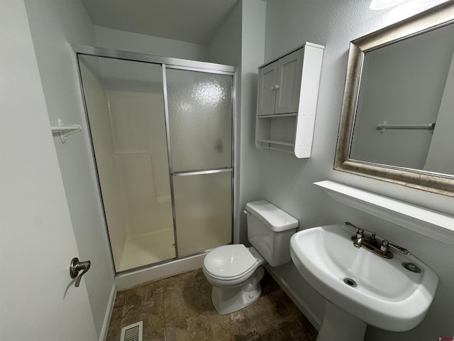 bathroom with toilet, walk in shower, and sink