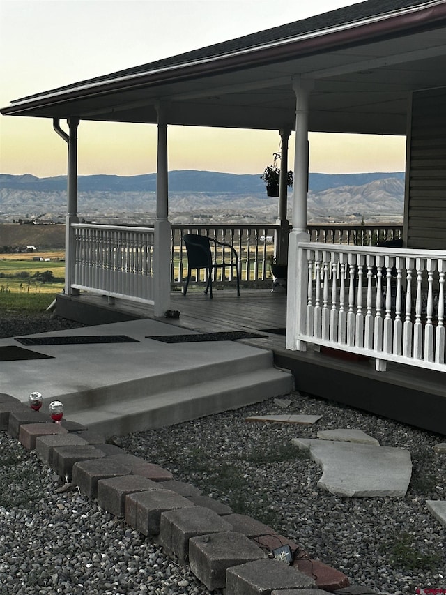 deck at dusk featuring a mountain view