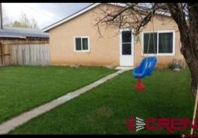 rear view of house featuring a yard